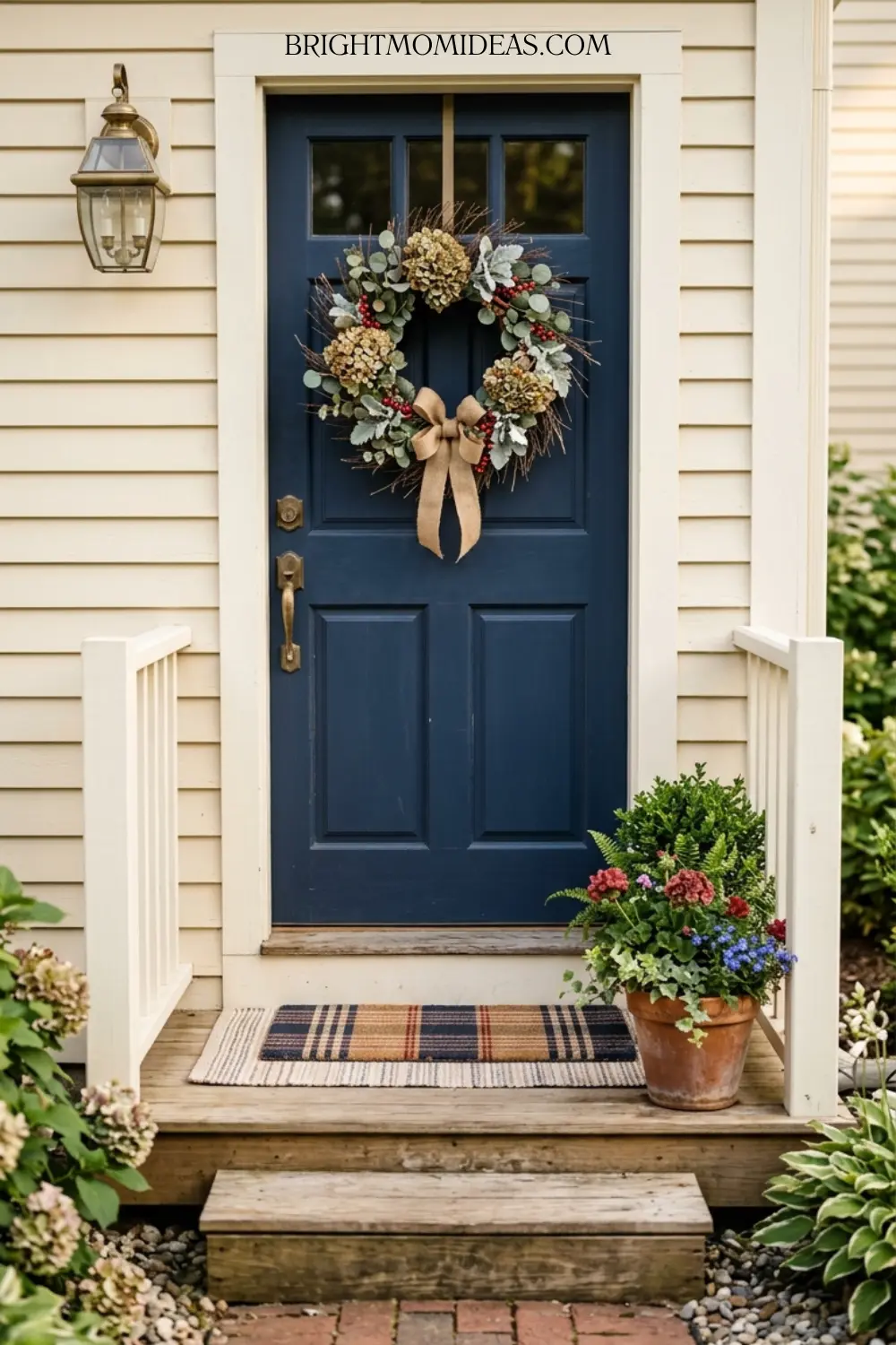 Small compact front entry with Americana wreath 
planter with red and blue blooms and layered 
doormat