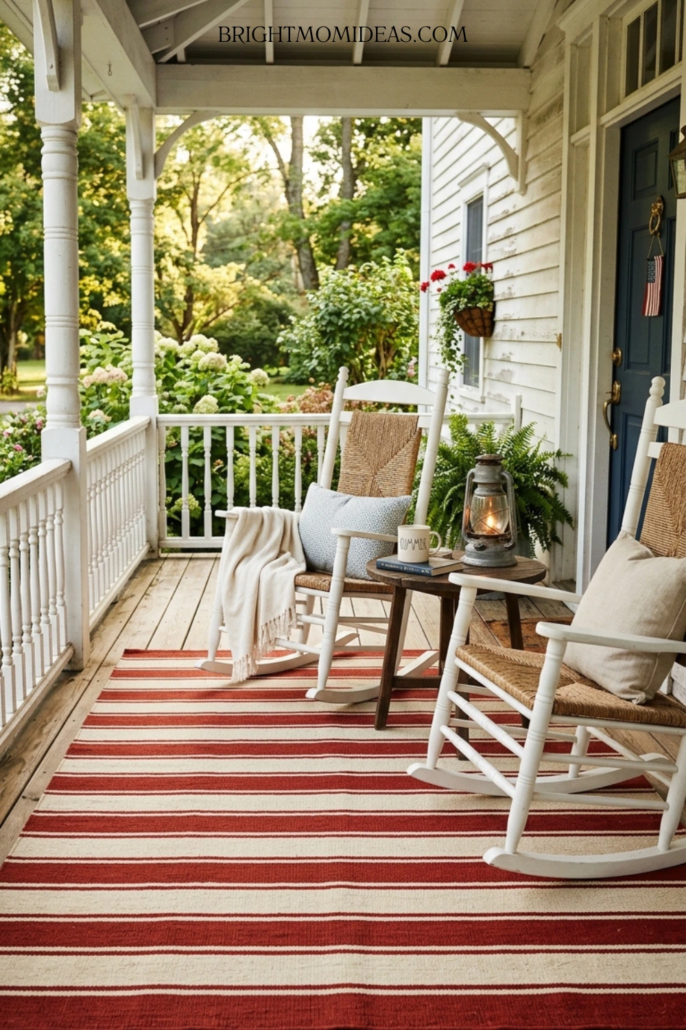 Deep brick red and antique cream striped outdoor 
rug on classic Americana front porch with rocking 
chairs and galvanized lantern
