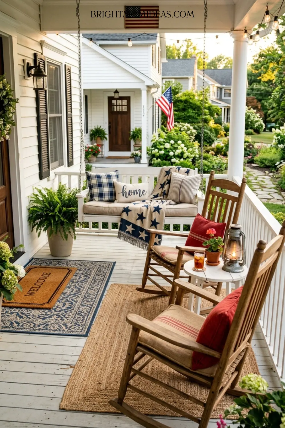 Two natural wood porch rocking chairs with deep 
brick red grain sack cushions on classic Americana 
front porch