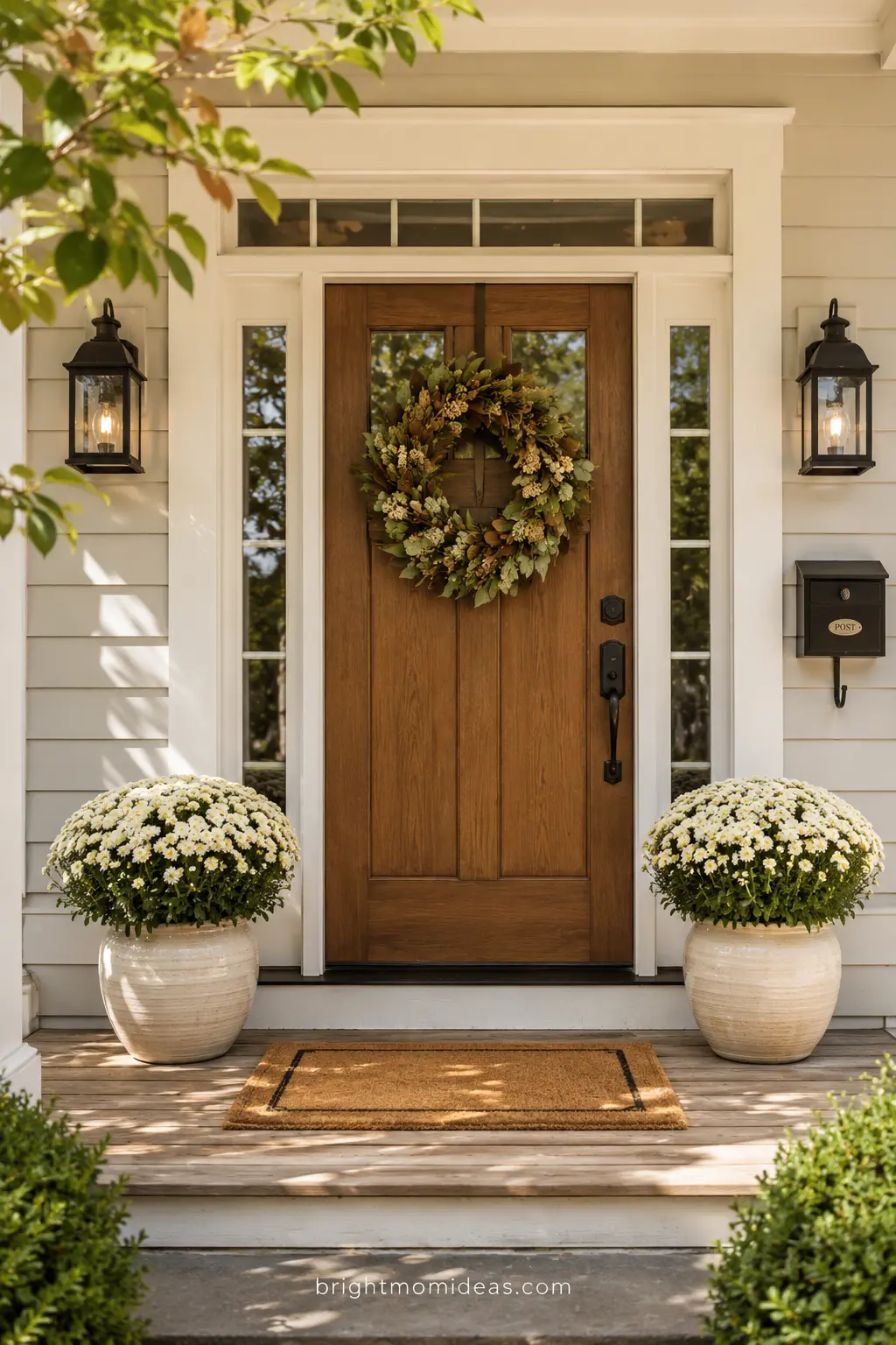 Styled front door entrance with wreath, mums, and fall doormat